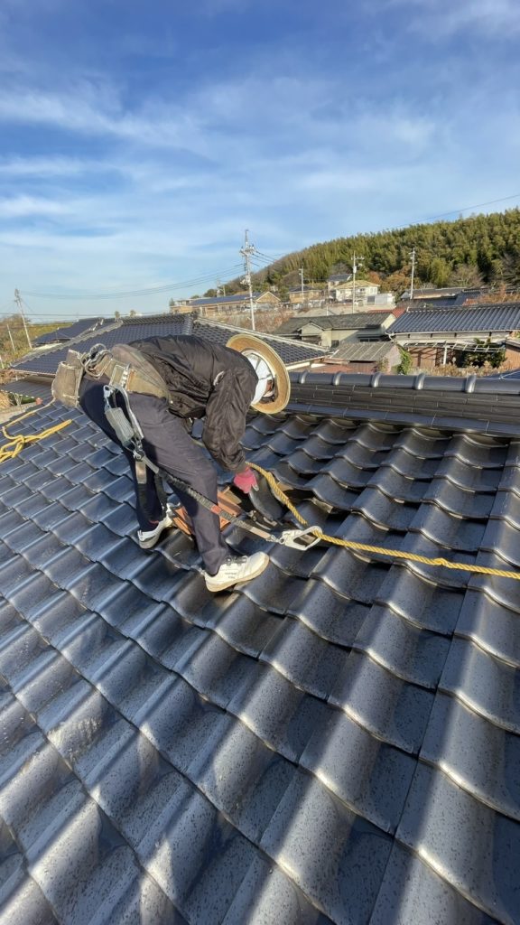 安全帯をして瓦はぎをする写真